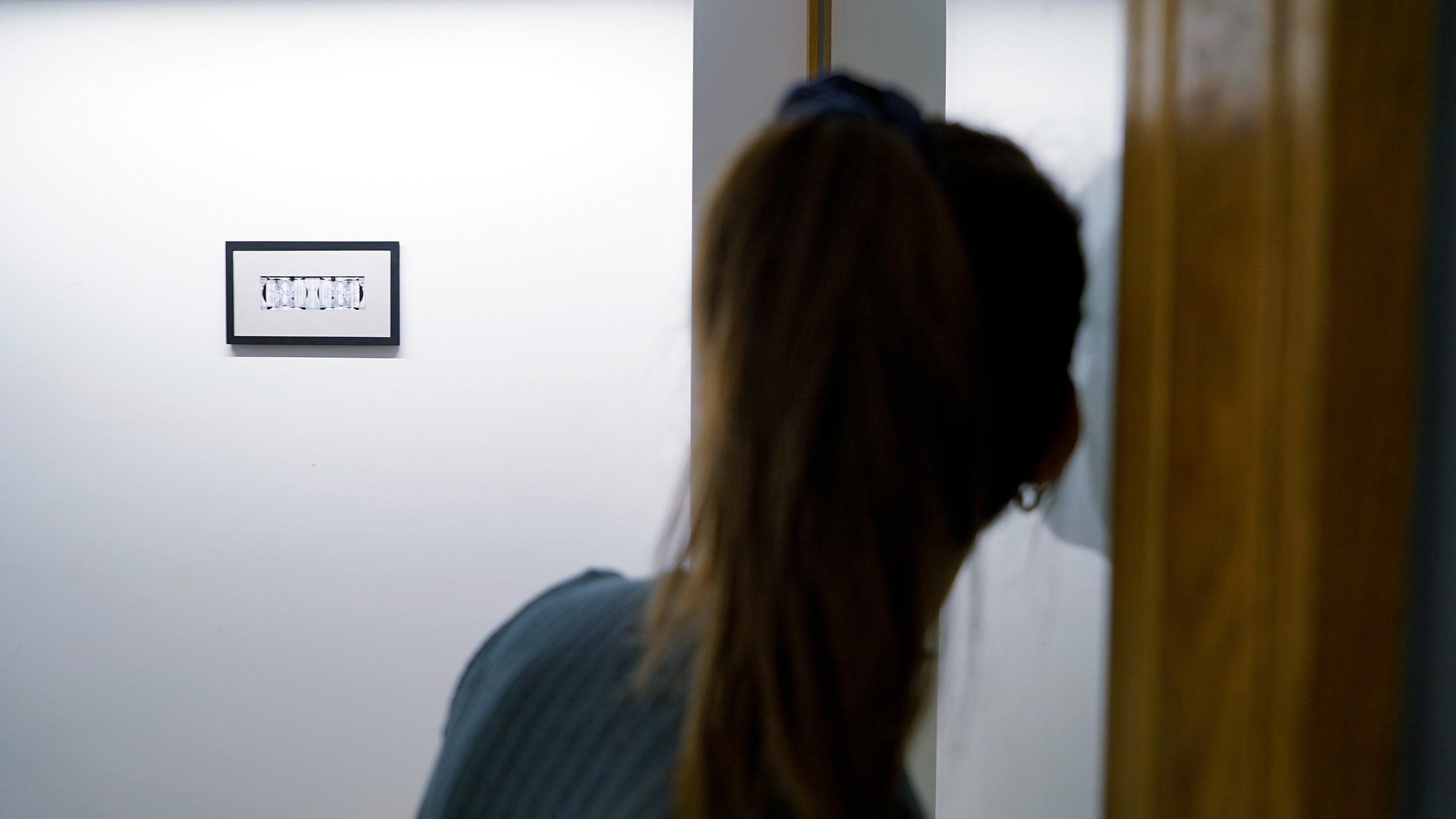 Visitor listening sound diffused by vibrant speakers installed on the window. Photo by Fragmentin